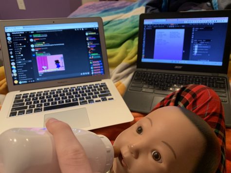 Sophomore Laura Rairdin-Hale feeds her RealCare baby as she does homework, 2022